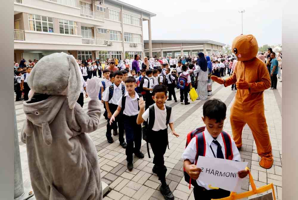 Murid-murid Tahun Satu ceria ketika disambut oleh maskot pada hari pertama persekolahan sempena pembukaan sekolah sesi akademik 2024/2025 di Sekolah Kebangsaan Saujana Putra, Jenjarom pada Isnin. Foto Bernama