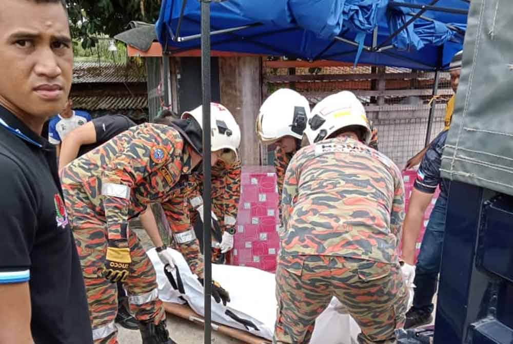 Anggota bomba mengangkat mangsa yang dipercayai terkena renjatan elektrik di Kampung Datu Pangeran Batu 7, Sandakan.
