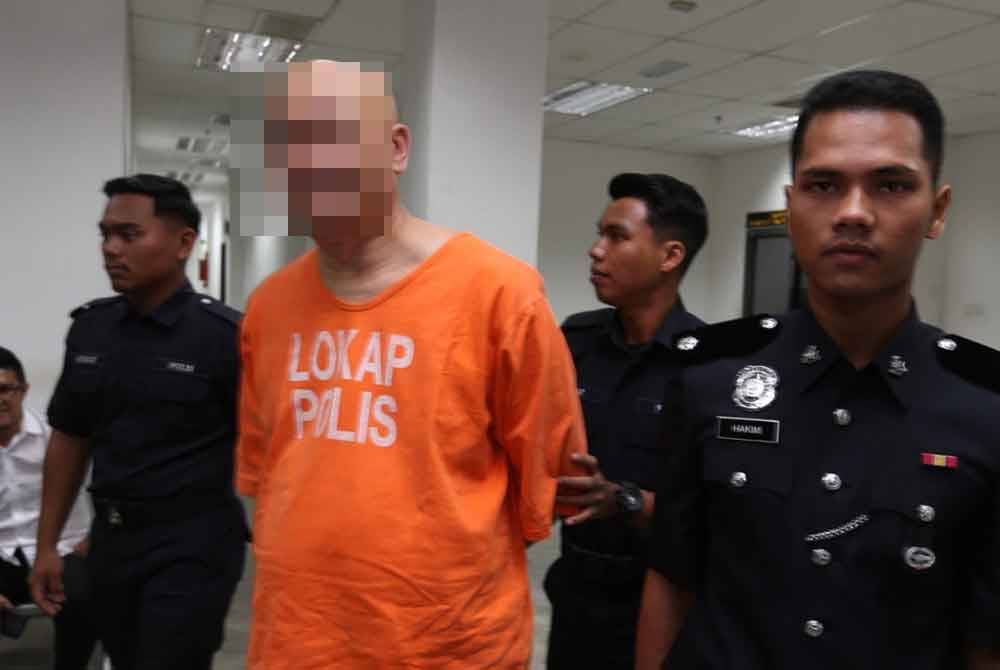 Suspek memakai baju lokap berwarna jingga tiba di Mahkamah Majistret, pada Isnin.