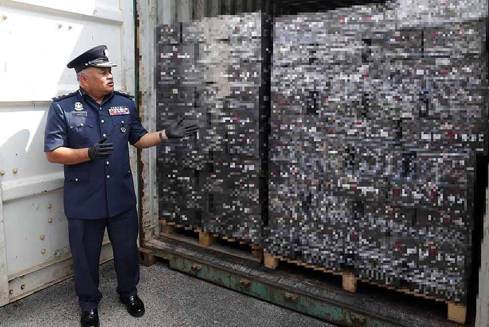 Mohammad Hafiz menunjukkan minuman keras yang dirampas ketika mengadakan sidang media mengenai dua sindiket pengedaran rokok putih dan minuman keras bernilai lebih RM13 juta di Pejabat Kastam Negeri Sembilan. Foto Bernama