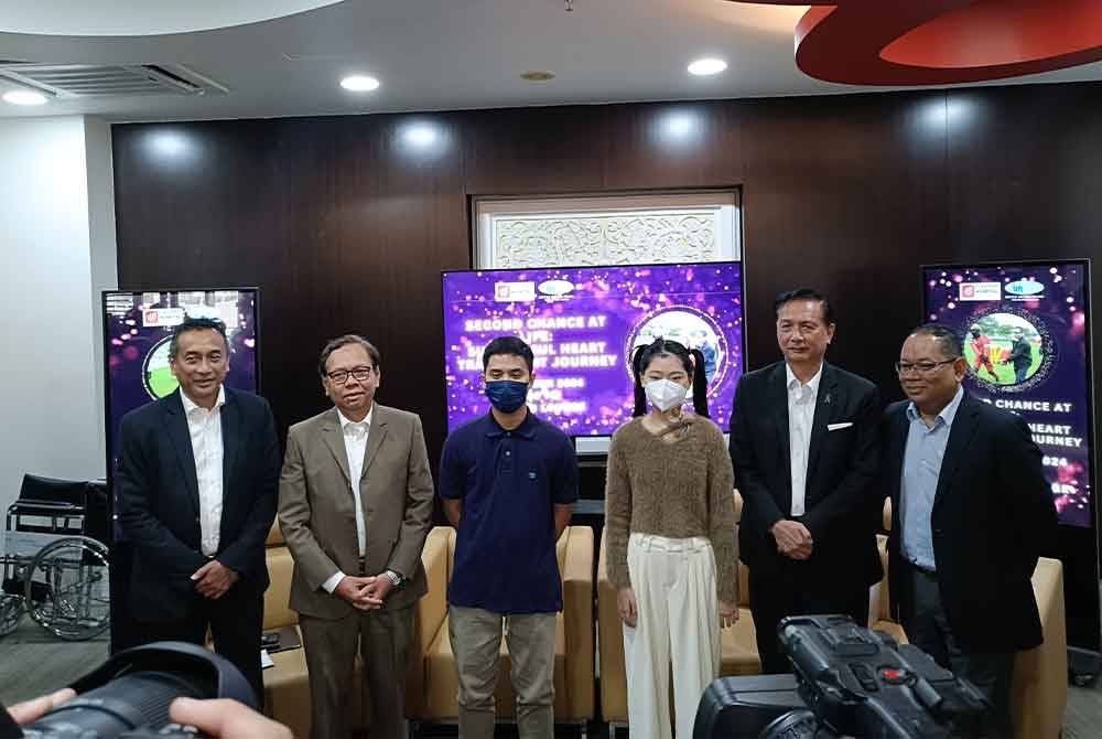 Noor Hisham (dua dari kanan) dan Aizai Azan (dua dari kiri) dan tetamu kehormat lain bergambar bersama dua pesakit (tengah) yang telah berjaya melaksanakan pemindahan jantung di IJN.