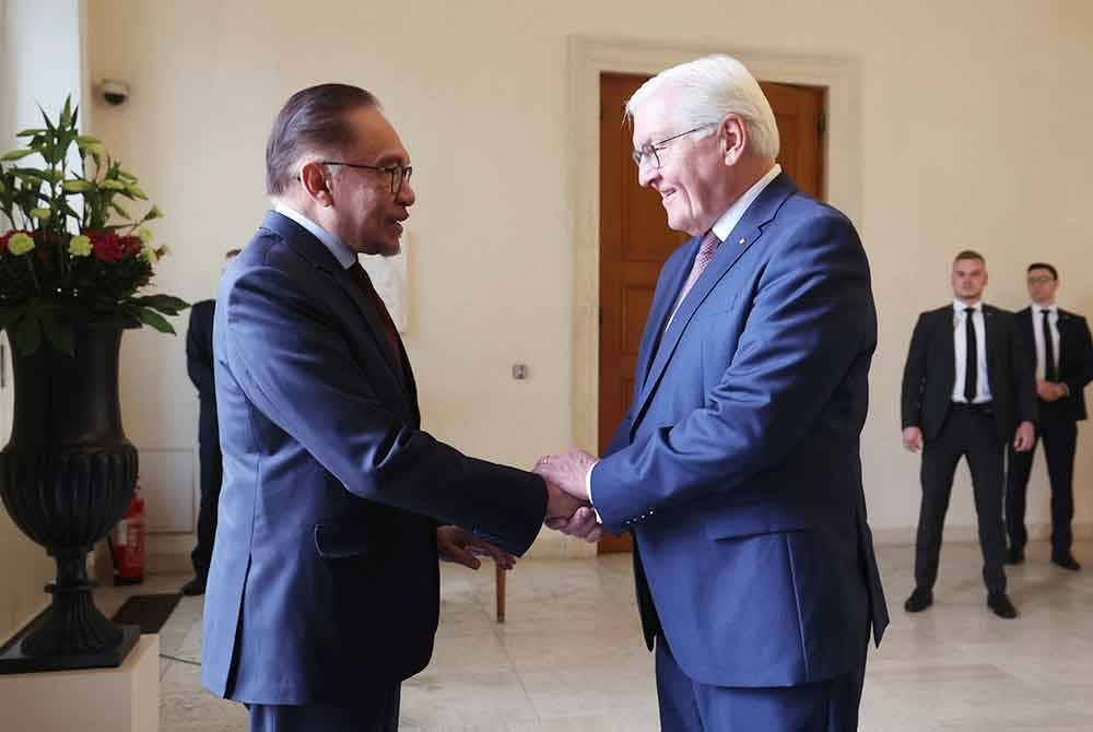 Anwar (kiri) disambut mesra oleh Presiden Steinmeier semasa mengadakan kunjungan hormat di Bellevue Place. Foto Bernama