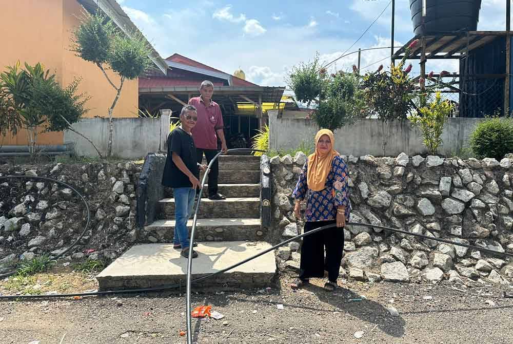 Penduduk menunjukkan paip yang disambung ke masjid untuk mendapatkan air dari telaga tiub.