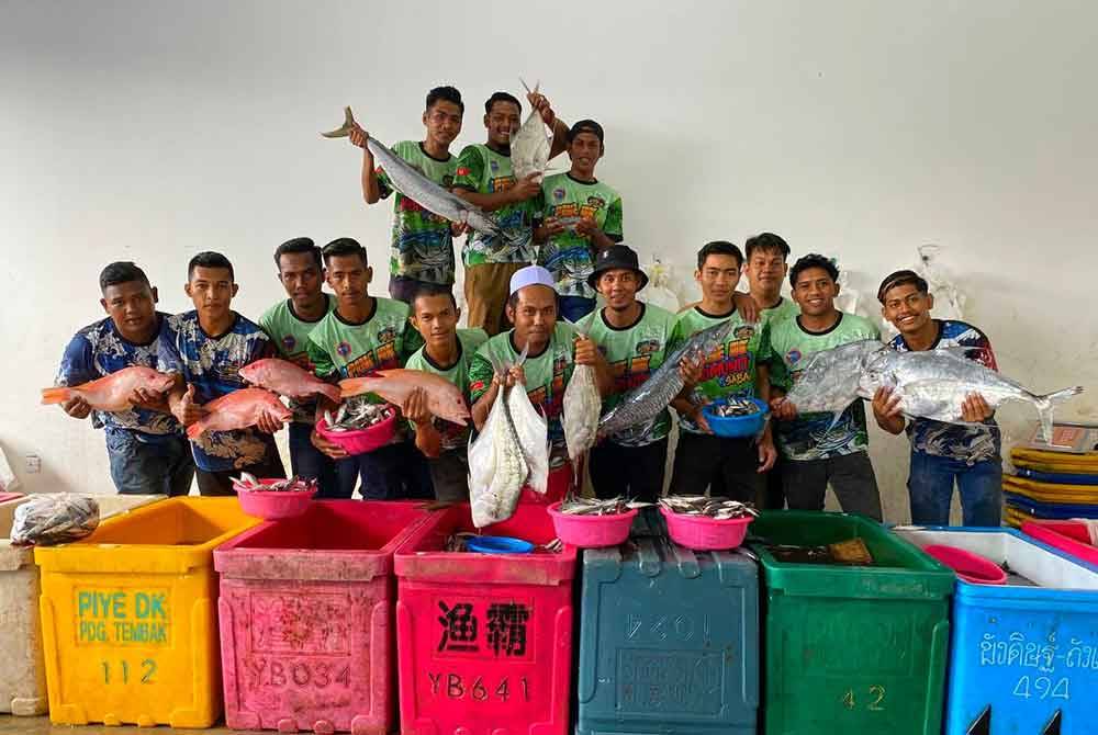 Zuhairi (tengah) bersama pekerjanya menunjukkan lebih 20 jenis ikan yang turut dijual di kedainya dengan harga bawah RM10 untuk setiap kilogram.