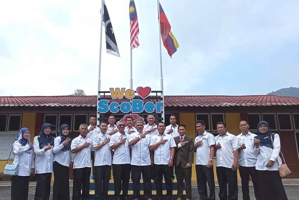 Jelani (enam dari kiri) bersama Shafruddin (tujuh dari kanan) merakam gambar bersama tenaga pengajar dan kakitangan SK Sungai Berua di Hulu Terengganu.
