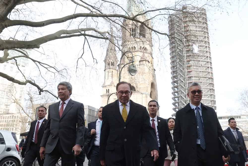 Anwar (depan, tengah) diapit Menteri Luar, Datuk Seri Mohamed Hasan (kiri) dan Tengku Zafrul berjalan kaki menuju ke Mesyuarat Meja Bulat Bersama Kapten Industri di Berlin, hari ini. Foto Bernama