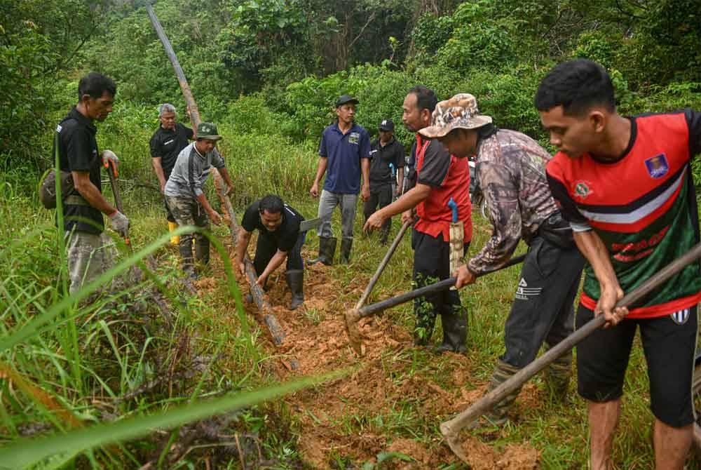 Penduduk bergotong-royong membersihkan kawasan dan memasang saluran paip.