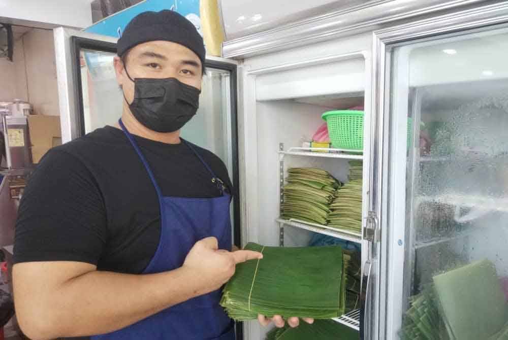 Che Mad menunjukkan daun pisang segar yang digunakan bagi membungkus nasi goreng seafood.