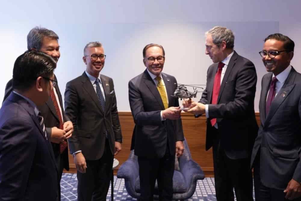 Perdana Menteri Datuk Seri Anwar Ibrahim melihat replika helikopter Airbus pada majlis Mesyuarat Perniagaan One to One pada Selasa. Foto Bernama