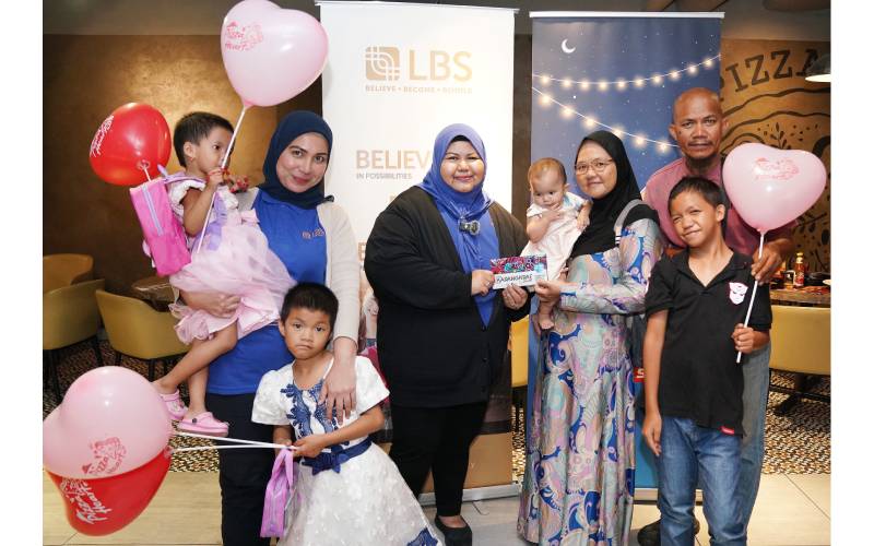 Pengurus Perhubungan Korporat dan Media Digital LBS, Norazian Abdul Aziz (tengah) menyerahkan sumbangan wang tunai kepada Nor Alia dan keluarganya.