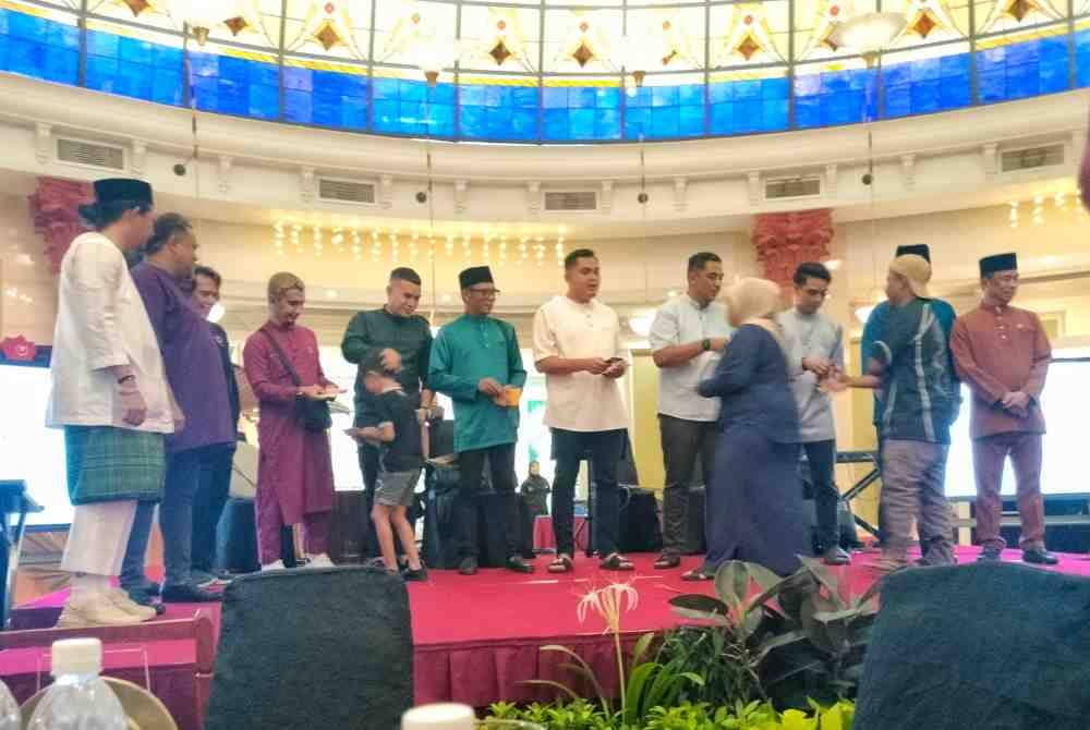 Muhamad Akmal (tengah) menyampaikan sumbangan kepada golongan yang diraikan pada Program Simpulan Kasih Ramadan di Hotel Grand Swiss Bell di sini, pada malam Rabu.