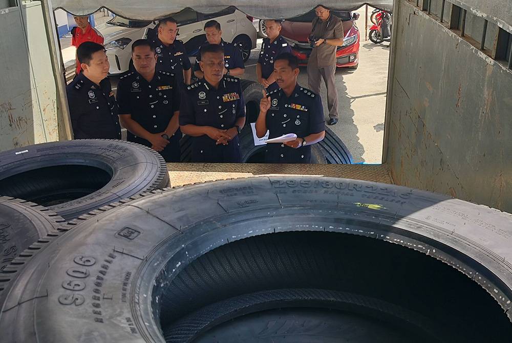 Wan Mohd Zahari (dua dari kanan) bersama pegawainya menunjukkan sebahagian tayar curi dalam lori yang dirampas susulan penahanan tiga anggota Geng Vennu pada 4 Mac lalu.