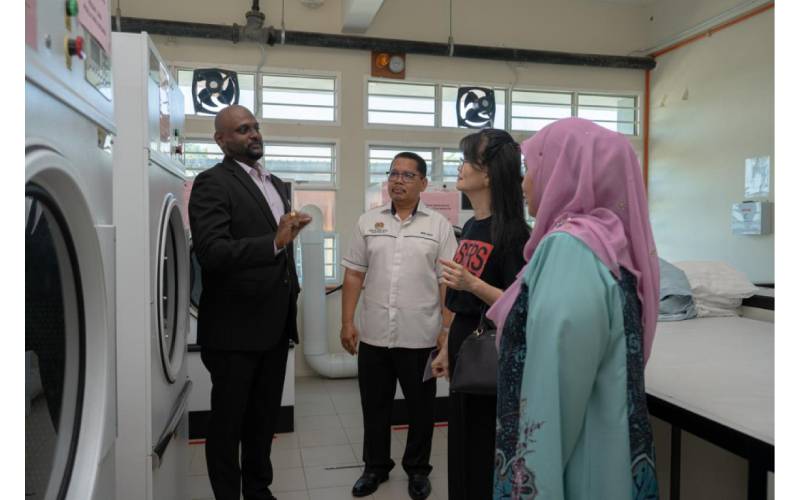 Cikgu Kumaresan (kiri) komited untuk menyediakan pekerjaan yang saksama untuk pelajar-pelajar berkeperluan khas dengan projek kedai dobi dan Pusat Latihan Rumah Tiruan di sekolah.