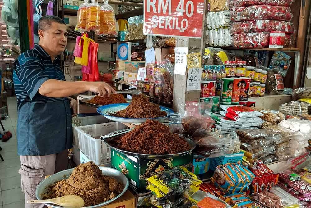 Peniaga serunding dan makanan kering, Ab Hamid Ab Aziz, 56, memeriksa serunding yang dijual di Pasar Besar Siti Khadijah di sini. - Foto Bernama