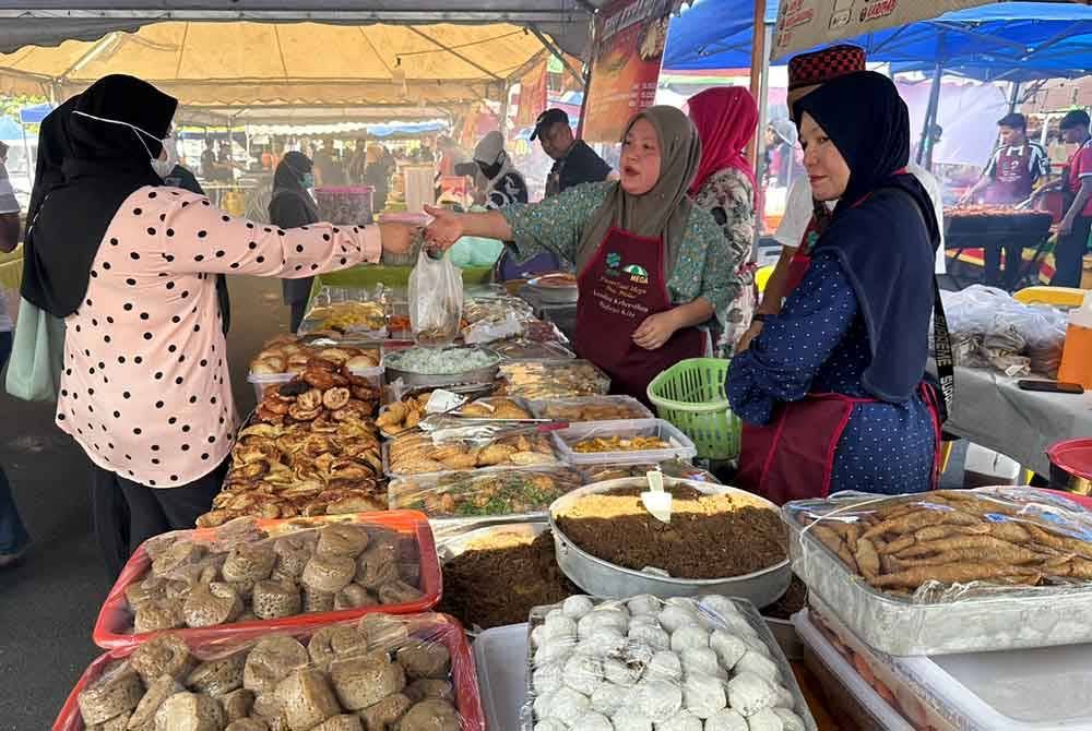 Pelanggan yang membeli kuih-muih di gerai Nur Asmak.