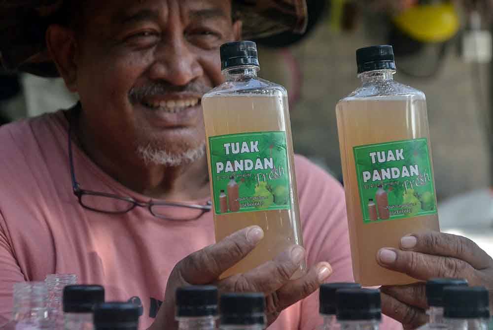 Ab Aziz menunjukkan air nira atau lebih dikenali air tuak pandan yang dijual ketika ditemui pemberita di Kampung Lepan Jaya di sini. - Foto Bernama