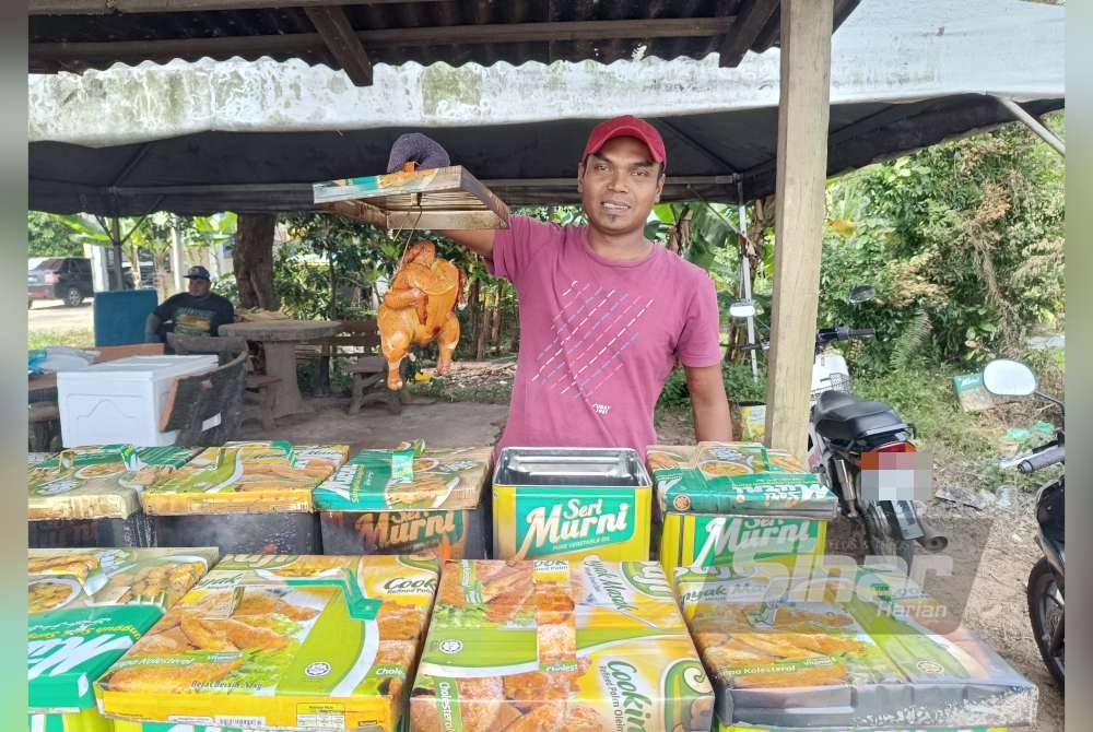 Mohd Lokman menunjukkan Ayam Teng Tok Jiring yang siap dibakar di gerainya dekat Kampung Tok Jiring, Kuala Nerus pada Khamis.