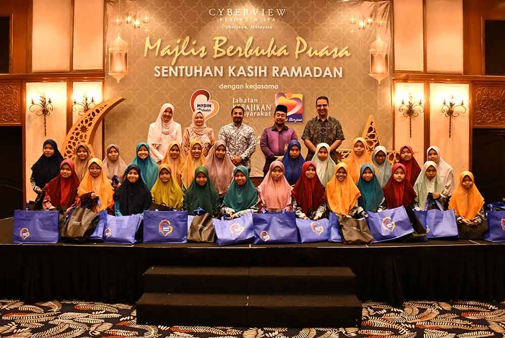 Hussain (kanan) bersama anak-anak yatim dalam Majlis Berbuka Puasa Sentuhan Kasih Ramadan di Cyberview Resort and Spa, di sini pada Jumaat.