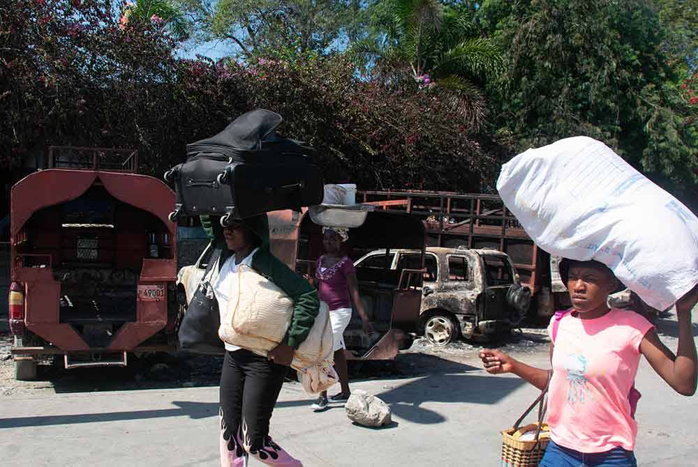 Orang ramai menyelamatkan barang-barang mereka ketika meninggalkan di Port-au-Prince.