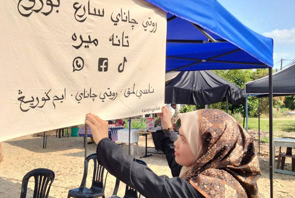 Fifi Nasuha menunjukkan tulisan jawi 'roti canai sarang burung' di gerainya.