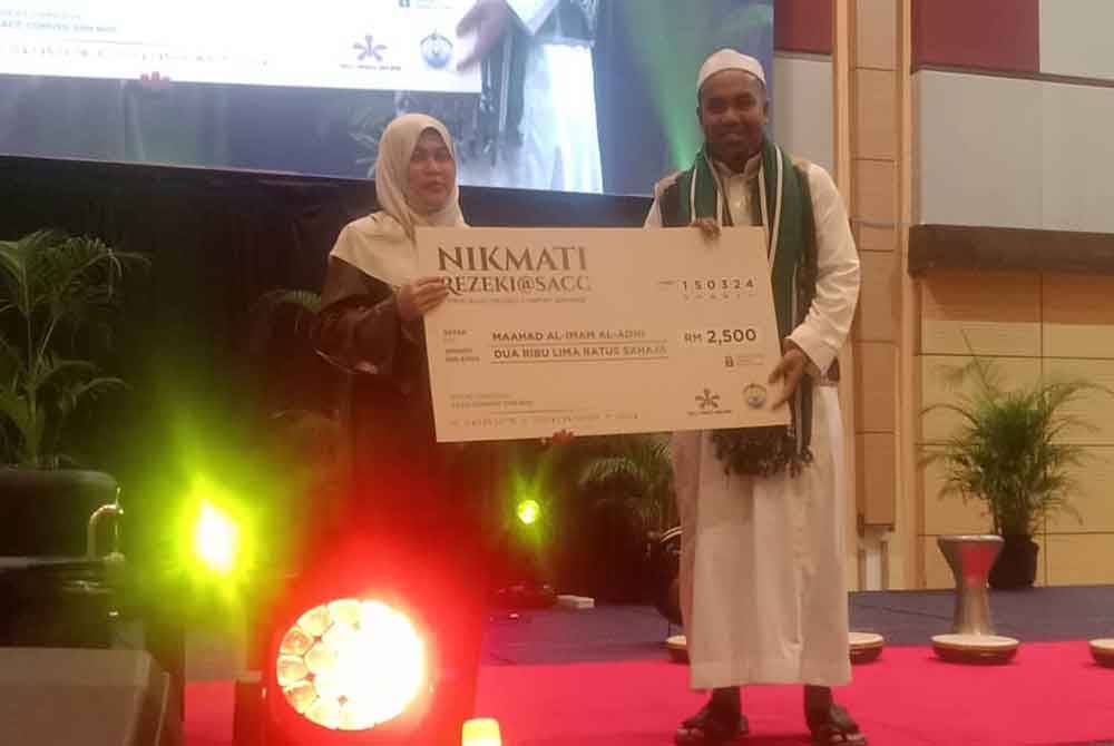 Azlina (kiri) mewakili SCSB turut menyalurkan sumbangan sebanyak RM5,000 kepada rumah kebajikan dan maahad tahfiz.