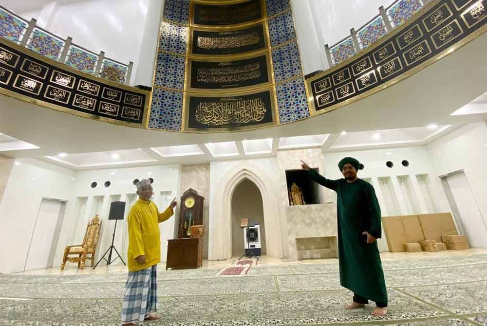 Nik Saiful Adli (kanan) menunjukkan reka bentuk dalaman Masjid Imanul Fa'izin di Padang Kala, Kota Bharu.