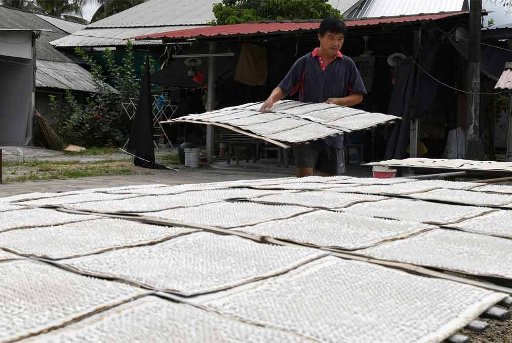 Seong Huat menjalankan proses pengeringan bedak sejuk di kediamannya di kampung Jalan Bahru. Foto Bernama