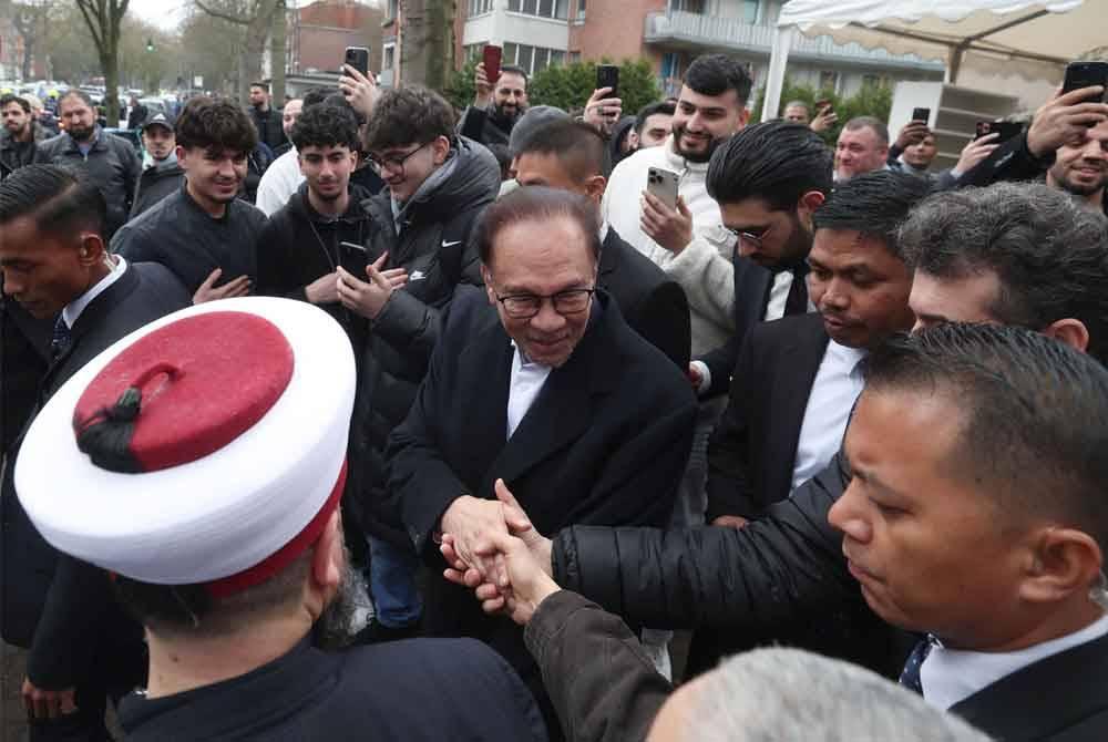 Anwar Ibrahim bersalam dengan jemaah selepas menunaikan solat Jumaat di Masjid Al Nour, Hamburg. Foto Bernama