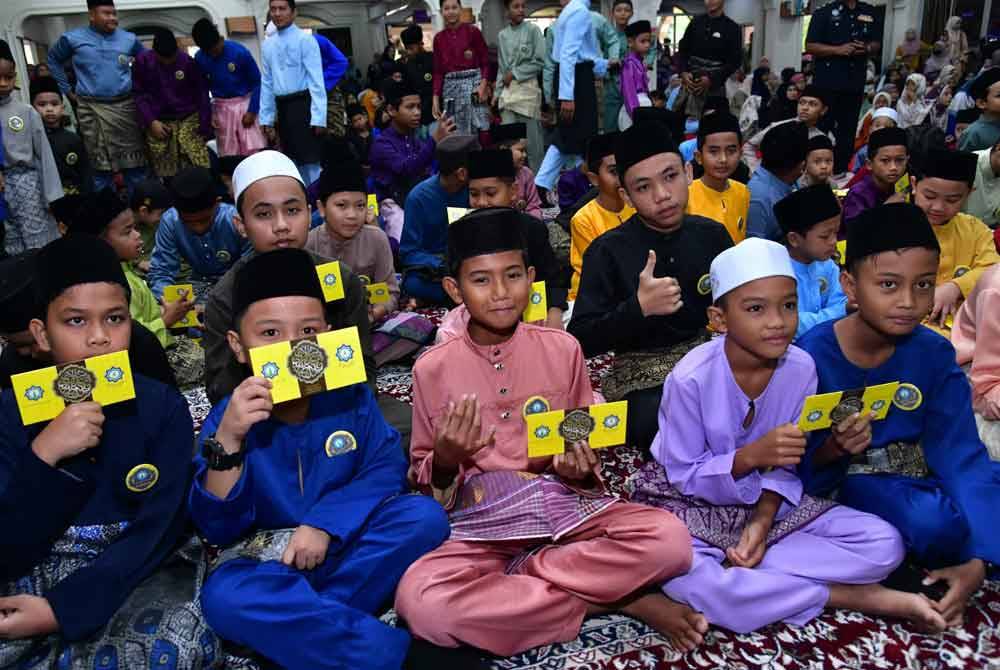 Anak yatim di Kuala Lamgat menunjukkan sumbangan Aidilfitri yang diterima.
