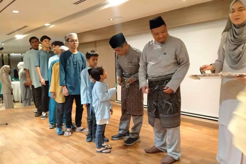 Zahar (tiga dari kanan) menyampaikan sumbangan kepada anak-anak yatim dan asnaf sempena Majlis Iftar Bersama Anak-Anak Yatim dan Asnaf anjuran DPMP bersama Zahar Advisory Group di Dewan Serbaguna Bangunan Tabung Haji di sini pada Sabtu.