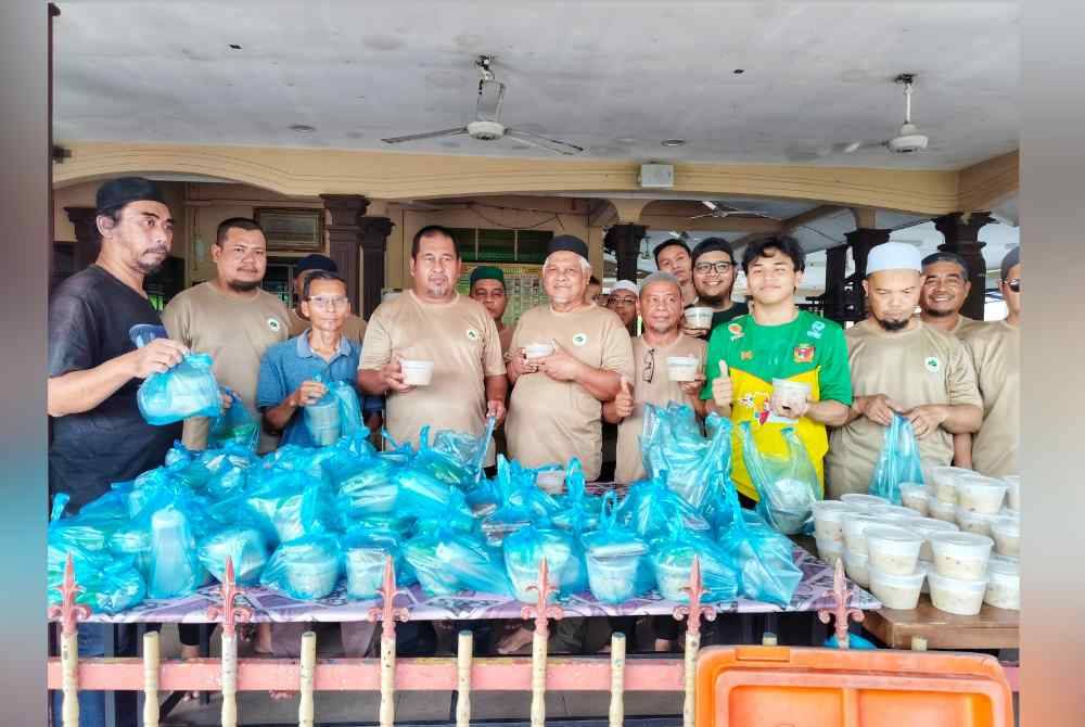 Ahli jawatankuasa surau Az Zaharah menunjukkan makanan yang telah dibungkus untuk diedarkan kepada penduduk.