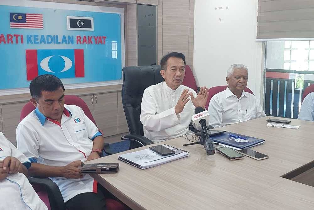 Azan (tengah) ketika sidang akhbar di Bangunan Keadilan pada Ahad.