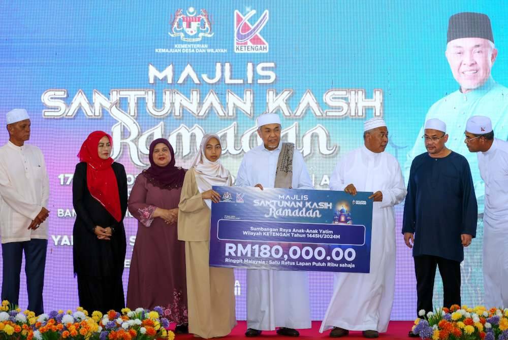 Ahmad Zahid (empat dari kanan) menyerahkan sumbangan kepada anak-anak yatim Wilayah Lembaga Kemajuan Terengganu Tengah (Ketengah) pada Majlis Santunan Kasih Ramadan bersama Kementerian Kemajuan Desa dan Wilayah 2024 di Masjid Sultan Mahmud Bandar Al Muktafi Billah Shah. Foto Bernama