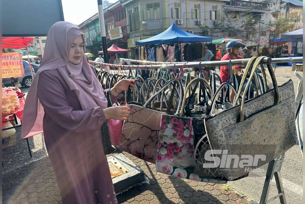 Suriati menunjukkan pelbagai beg yang dijual di Medan Ilmu pada setiap Jumaat.