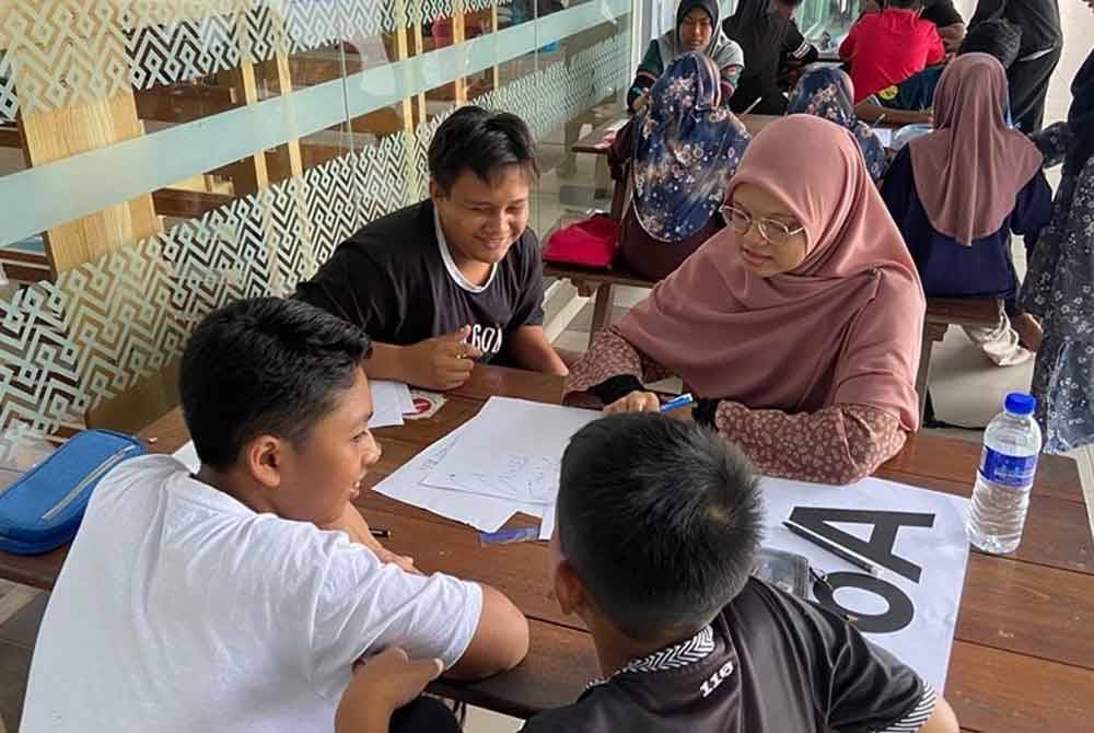 Seorang mahasiswa UTM mengajar pelajar asnaf secara percuma. Foto UMT