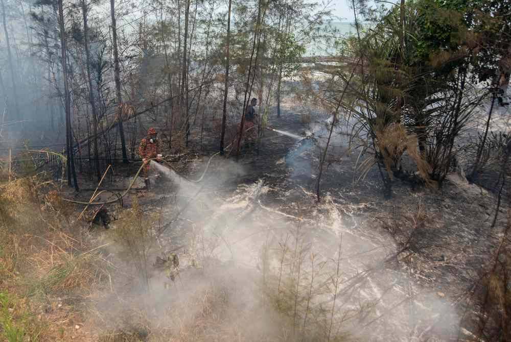 Anggota JBPM Labuan memadam kebakaran hutan dan belukar di sepanjang Jalan Pesisir Pantai di Kampung Nagalang berikutan cuaca panas dan kering yang melanda sejak beberapa minggu di pulau ini. Foto Bernama