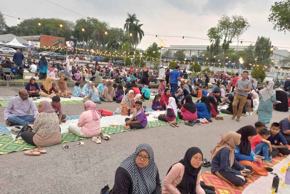 Orang ramai menunggu azan untuk berbuka puasa di Dataran Karangkraf, Shah Alam.