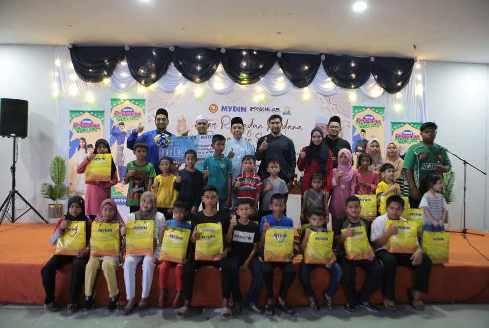 Muhammad Radhi (belakang dua kiri) bersama penerima sumbangan raju raya di Pasar Raya anjuran Mydin, Alor Setar pada petang Isnin.