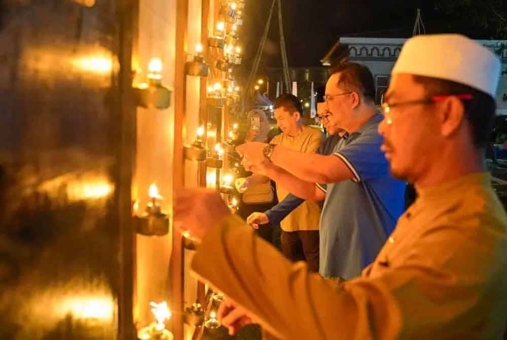Ahmad Ridzwan (dua dari kanan) melihat keunikan pelita raya ketika melawat lokasi program di Taman Tamadun Islam (TTI) pada malam Isnin.