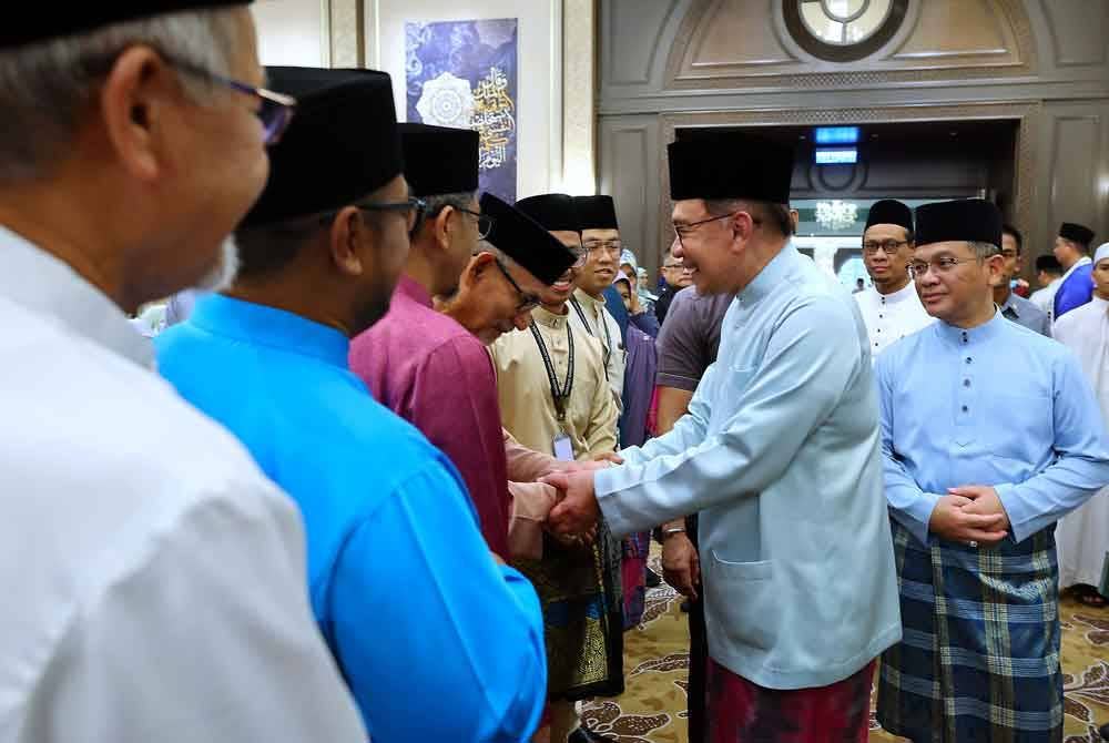 Anwar (dua dari kanan) beramah mesra bersama para tetamu yang hadir pada Majlis Berbuka Puasa Madani Perdana Menteri bersama Para Ilmuwan dan Agamawan di Kompleks Seri Perdana malam ini. Turut kelihatan Menteri di Jabatan Perdana Menteri, (Hal Ehwal Agama) Datuk Dr Mohd Na'im Mokhtar (kanan). Foto Bernama