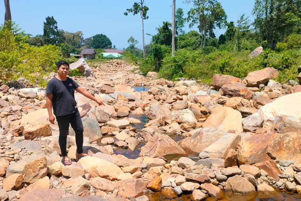 Firdaus menunjukkan keadaan air di kawasan peranginan Titi Hayun yang susut akibat cuaca panas.