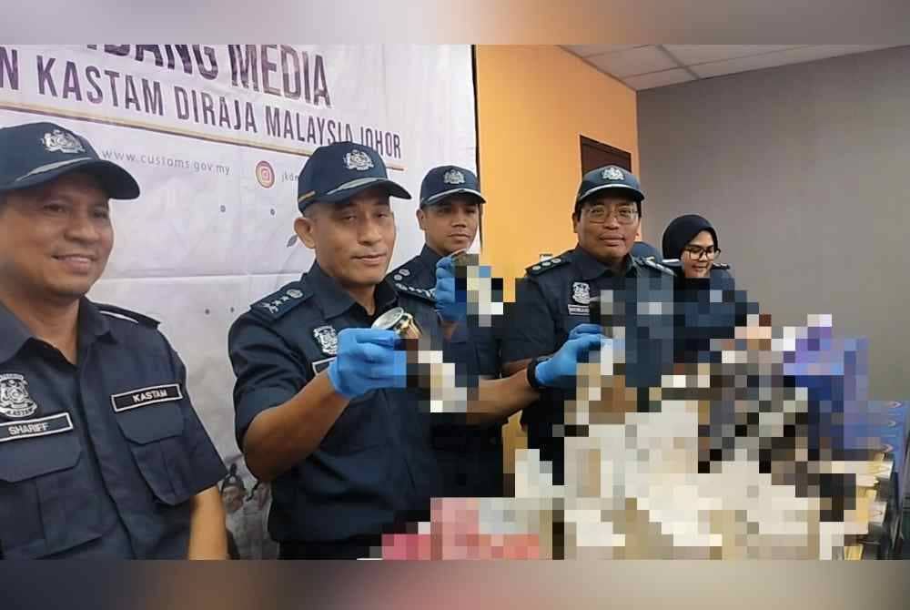 Aminul Izmeer (dua dari kiri) menunjukkan rokok dan minuman keras yang dirampas dalam sidang akhbar di Kompleks Sultan Abu Bakar (KSAB) Gelang Patah pada Rabu.