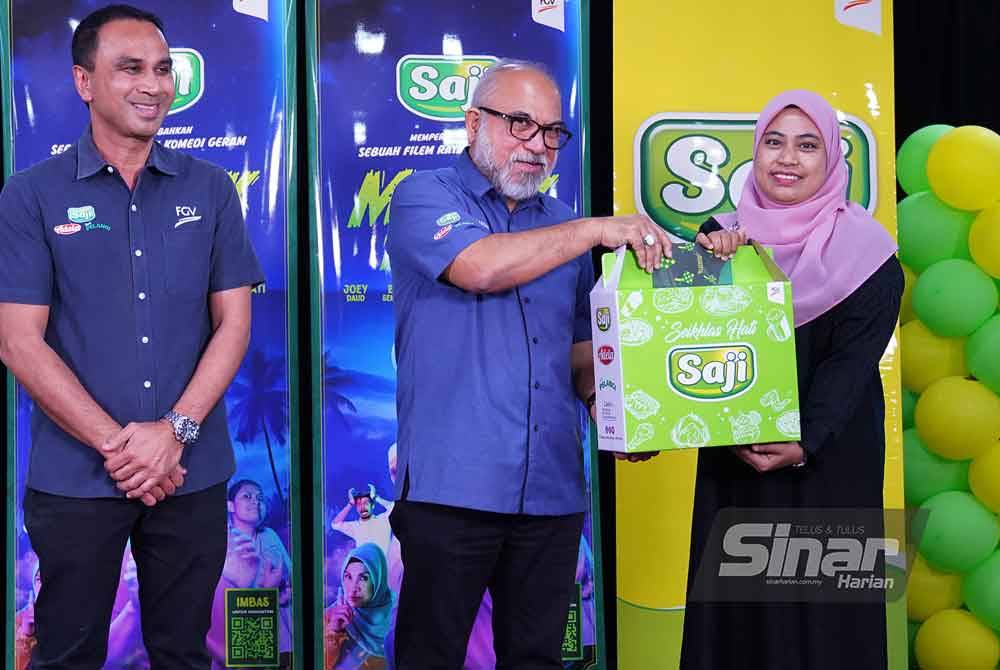 Rastam menyerahkan kotak hamper dan sumbangan wang tunai kepada penerima. Foto Sinar Harian - MOHD HALIM ABDUL WAHID