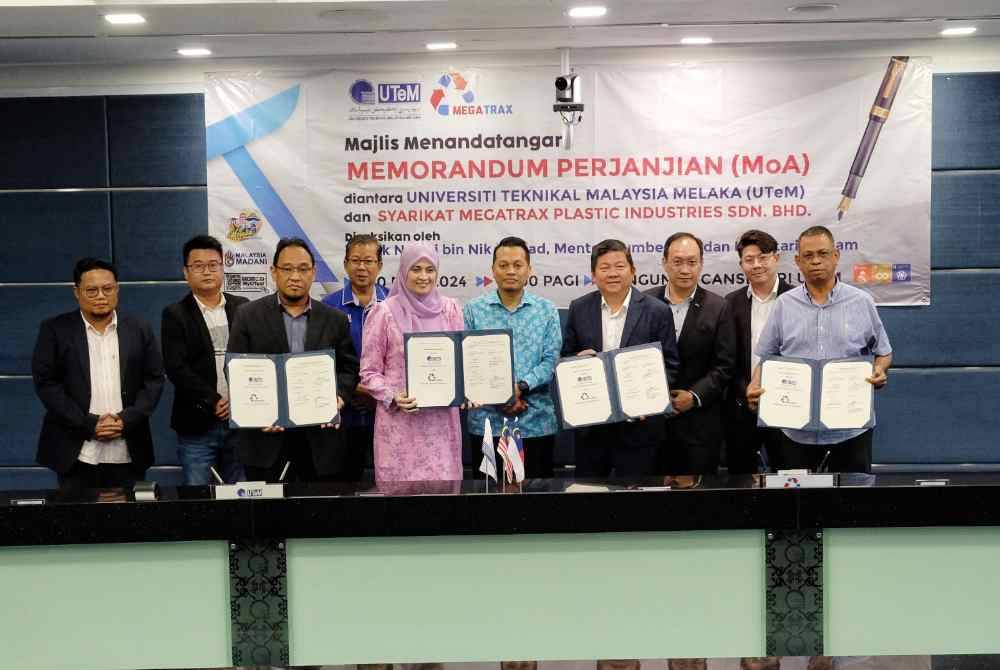 Nik Nazmi (empat,kiri) ketika menyaksikan Majlis Menandatangani Memorandum Perjanjian (MOA) antara Universiti Teknikal Malaysia Melaka (UTeM) dan Syarikat Megatrax Plastic Industries Sdn BHd di Kampus UTeM, Alor Gajah, di sini, pada Rabu.