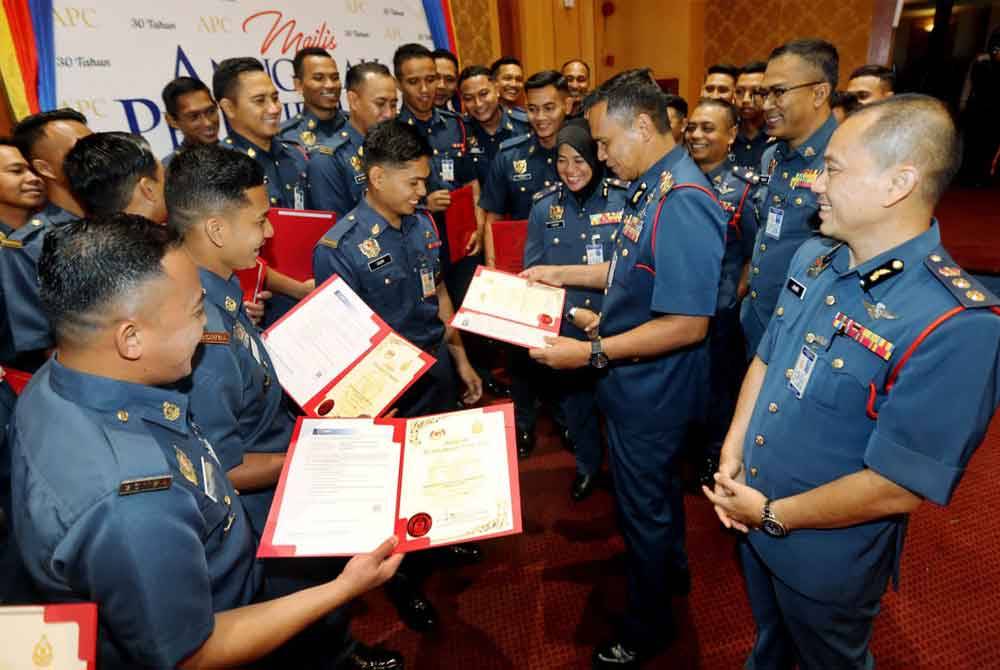 Nor Hisham (dua dari kanan) beramah mesra dengan penerima Anugerah Perkhidmatan Cemerlang dan Sijil Perkhidmatan 30 tahun JBPM Perak di Ipoh.