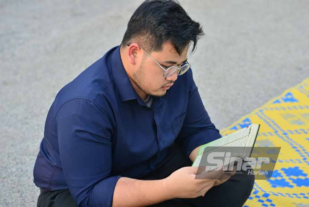 Seorang pengunjung membaca al-Quran sementara menanti waktu berbuka puasa. Foto Sinar Harian-ASRIL ASWANDI SHUKOR
