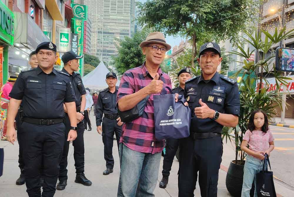 Mohd Azman menyantuni orang awam di sekitar Jalan Tuanku Abdul Rahman, Kuala Lumpur pada Rabu.