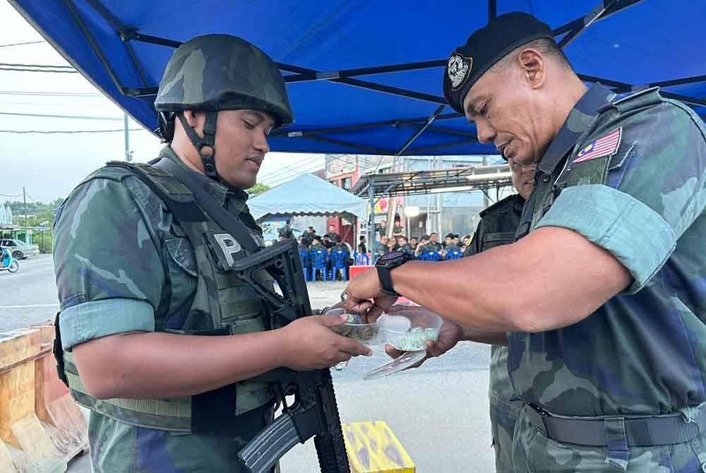 Sheik Azhar (kanan) beramah-mesra dengan anggota yang bertugas pada Op Taring Wawasan Kelantan.