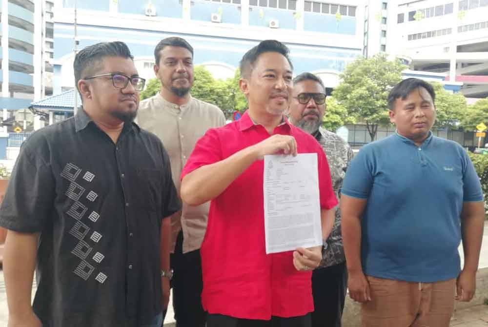 Isham (tengah) membuat laporan polis terhadap Farhash di IPD Dang Wangi pada Khamis.