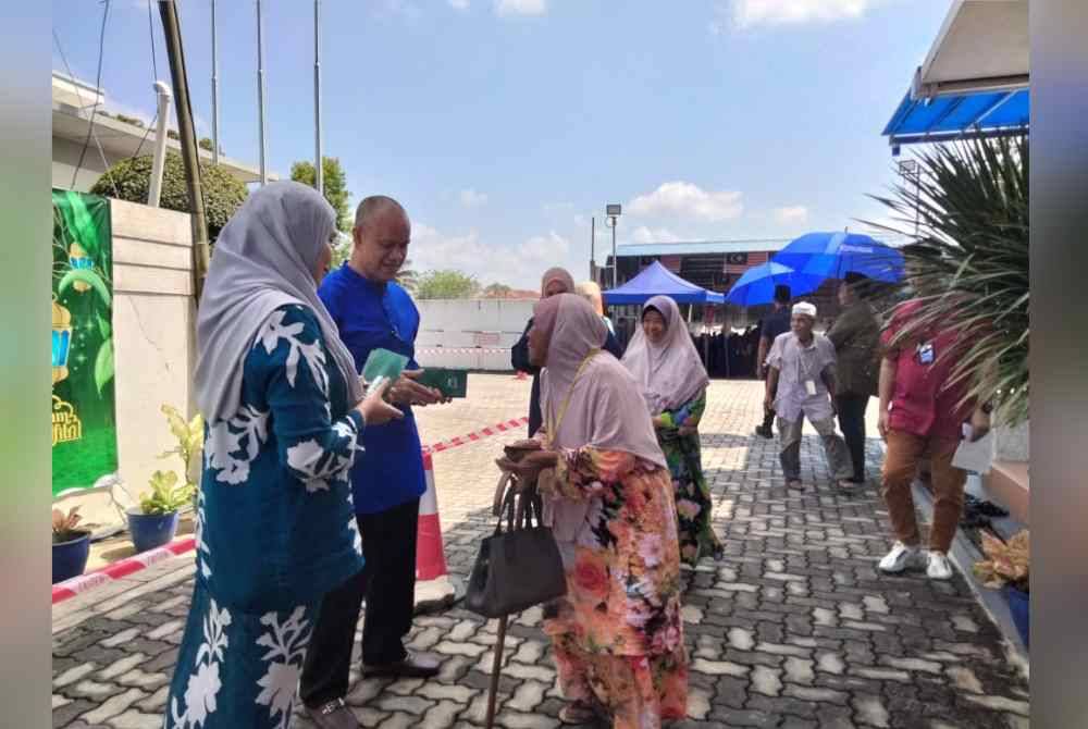 Che Ibrahim (tengah) menyampaikan zakat kepada warga emas yang memerlukan sempena Majlis Penyampaian Zakat Oleh Konsortium E-Mutiara pada Khamis.